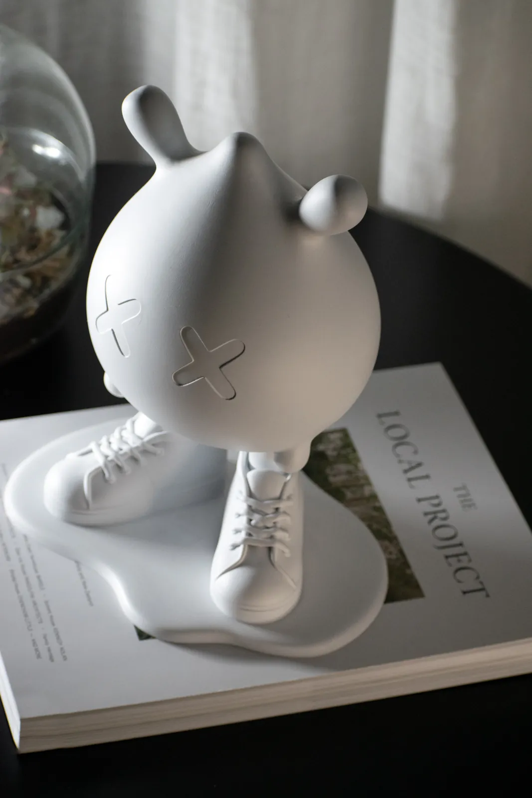 BuddyMelt bianco su un libro, accanto a un terrario
